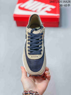 Top-down view showing the dark laces, brown eyelet panels, dark toe panel, and white midsole edge.