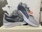 Pair of grey Nike basketball shoes shown from the side, with patterned overlays and white soles.
