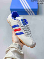Angled side view showing the white upper, blue and red stripes, lacing, and gum-colored outsole.