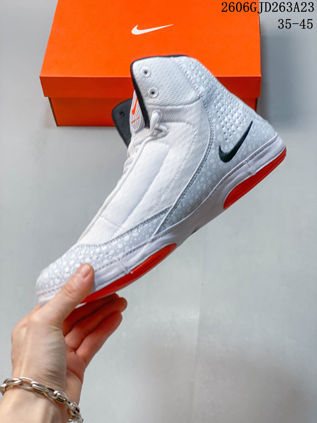 Side view of the high-top shoe with patterned overlays and orange outsole accents