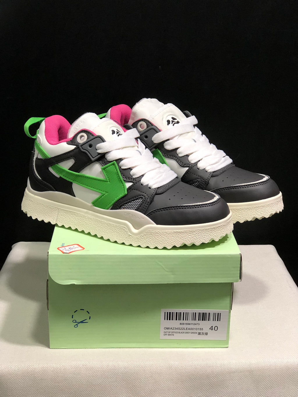 Pair of black, grey, white and green Off-White sneakers displayed on a green shoebox; the box label shows size 40 and the Out Of Office name.