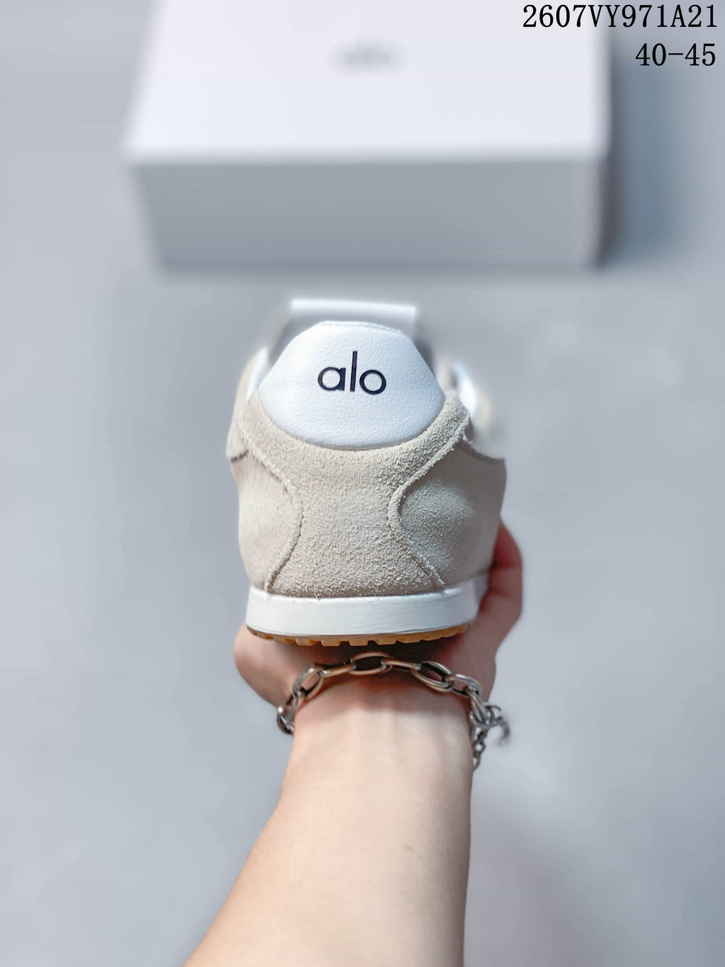 Rear view of the beige sneaker showing the white heel panel, Alo branding and gum outsole edge.
