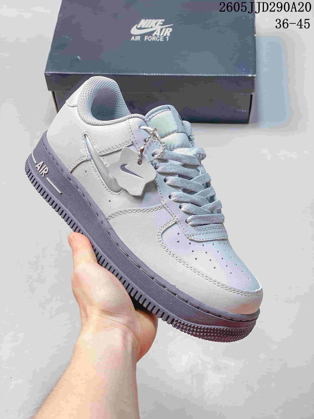 Pale gray and lavender low-top sneaker with a charm detail