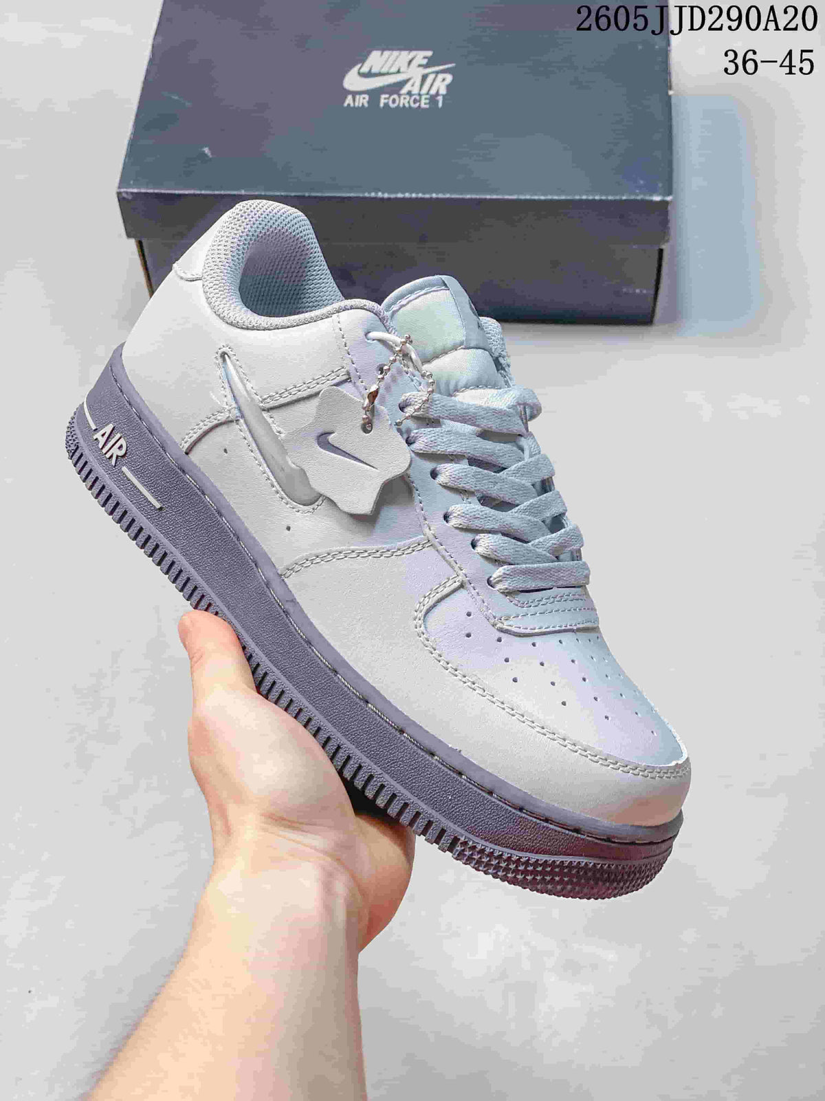 Pale gray and lavender low-top sneaker with a charm detail