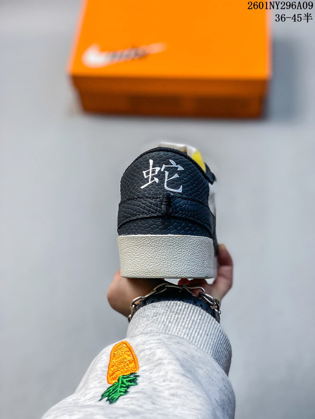 Rear view of the sneaker showing a black textured heel panel, white midsole, and white character detail on the heel.