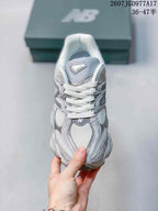 Front view of the gray New Balance 9060 sneaker showing white laces, mesh toe panels, and the layered upper.