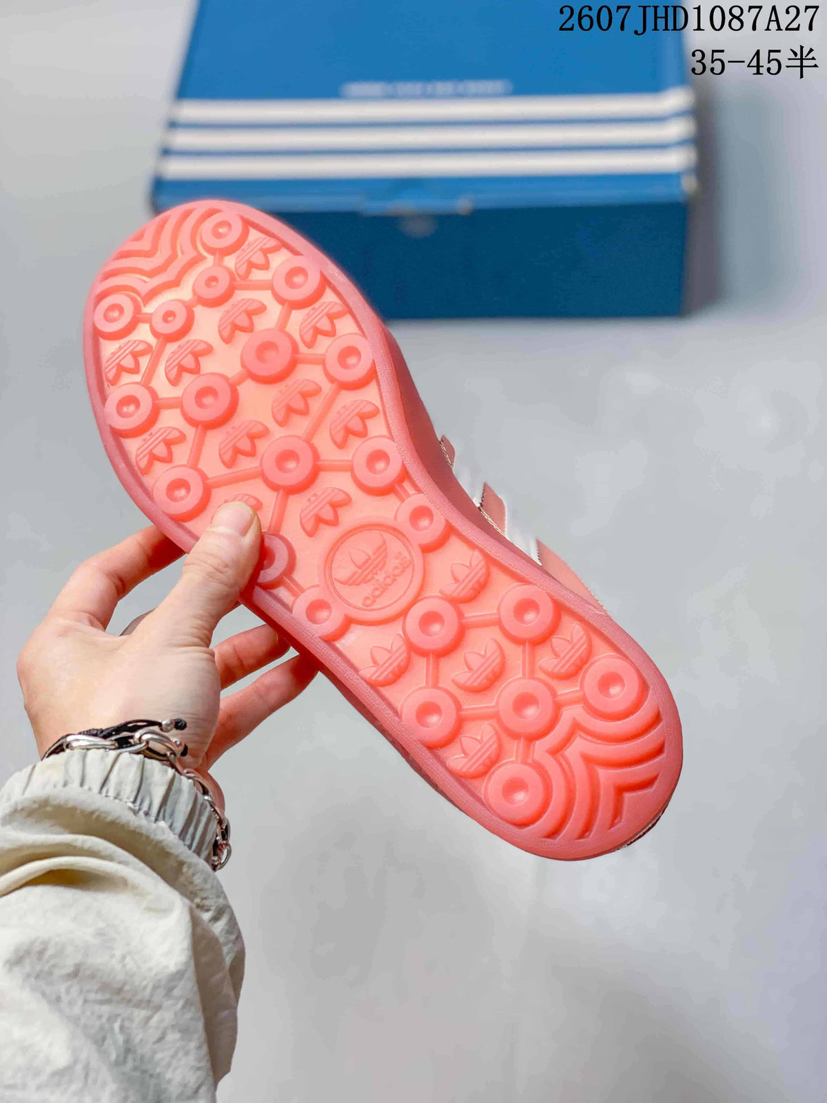 Close-up of the pink rubber outsole showing a textured circular and trefoil tread pattern.