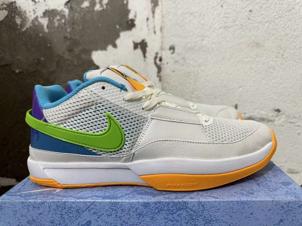 Side view of a white Nike Ja 1 shoe with mesh panels, a green side logo, blue and purple accents, and an orange outsole