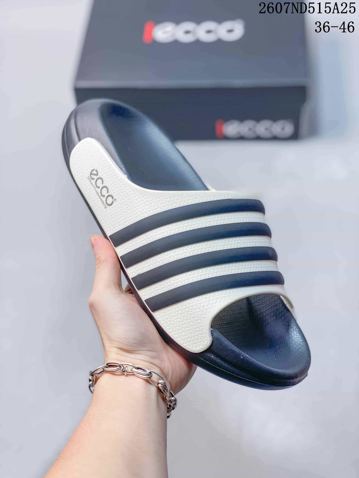 Close-up view of a white-and-navy striped ECCO slide sandal showing the open toe, textured upper, and molded footbed.