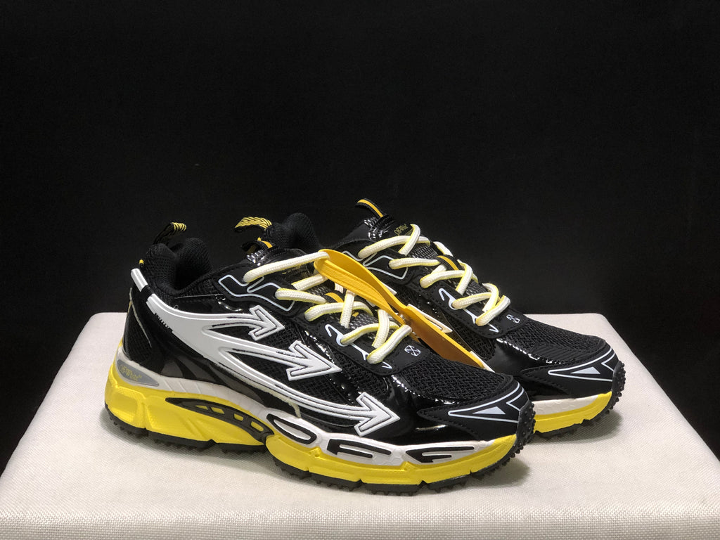 Three-quarter front view of the black sneakers with white arrow graphics, light laces, and yellow soles.