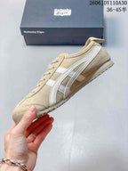 Side profile of a beige Onitsuka Tiger sneaker with white stripes