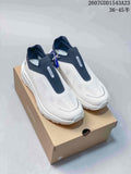 White and navy DESCENTE Primer slip-on sneakers displayed on a shoe box
