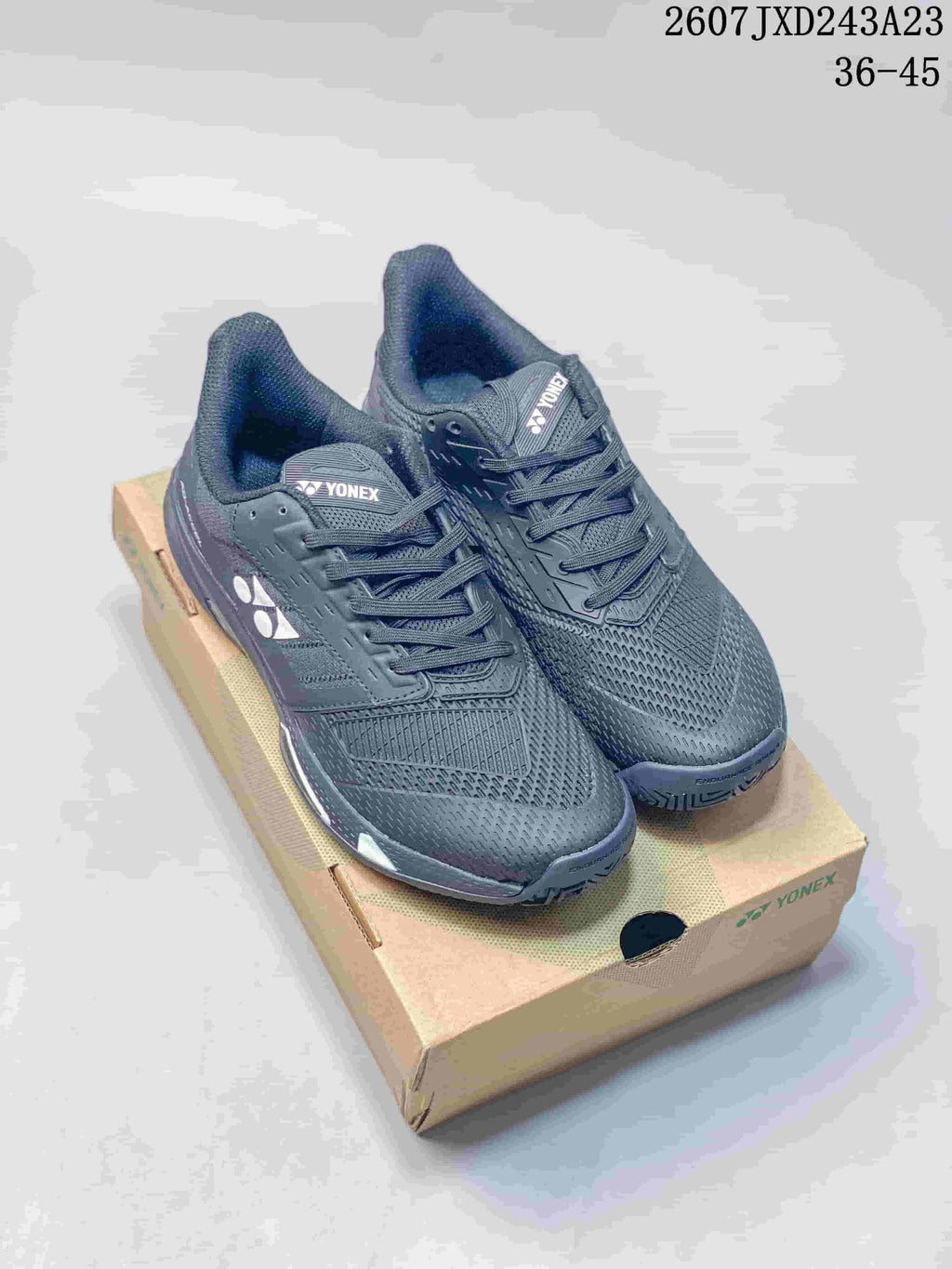 Pair of dark Yonex AD ACCEL tennis shoes displayed on a Yonex shoebox.