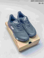 Pair of dark Yonex AD ACCEL tennis shoes displayed on a Yonex shoebox.