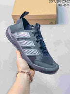 Angled side view highlighting the mesh upper, lace-up front, and textured outsole of a charcoal grey outdoor shoe.