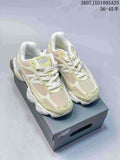 Pair of pale green, cream and white New Balance 9060R sneakers displayed on a shoebox.