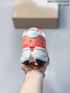 Rear view of a coral and white On running sneaker showing the padded heel and layered sole.