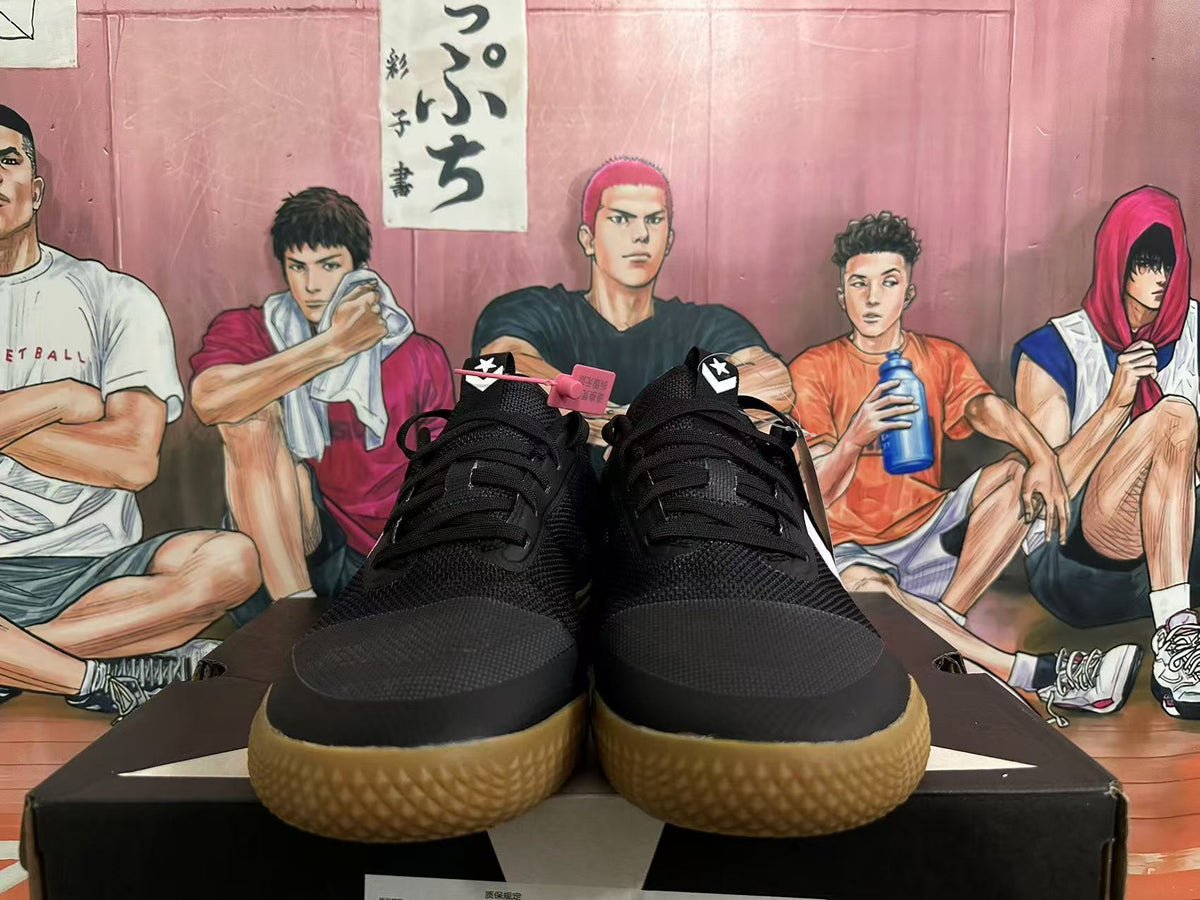 Front view of black lace-up low-top sneakers with gum-colored outsoles