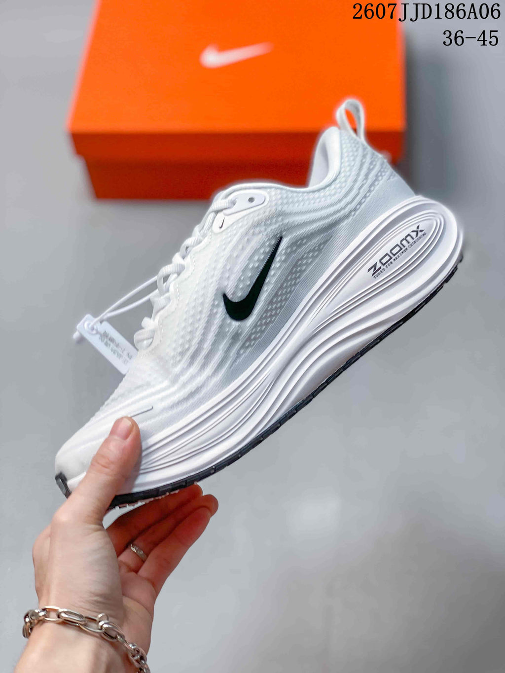 Side view of a white Nike running shoe showing the black Swoosh, textured upper and layered midsole.