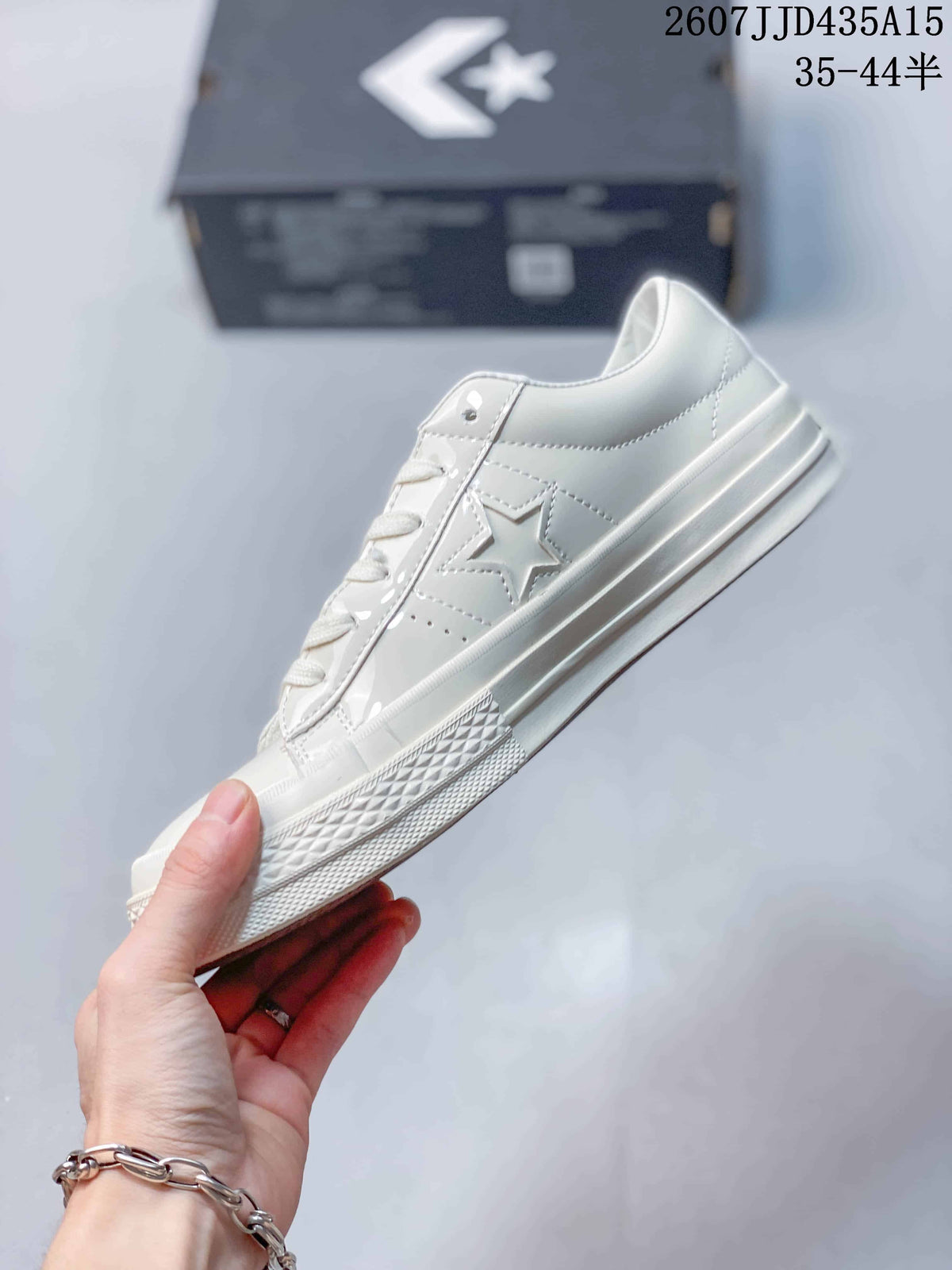 Side profile of the white low-top sneaker with its star side detail and textured outsole.