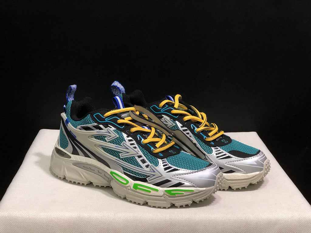 Three-quarter view of the pair highlighting the layered side panels and green sole accents.