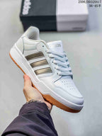 White adidas Entrap sneaker with muted gray side stripes and a gum-colored outsole.