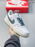 White Nike Court Vision Low sneaker with dark green details, dark laces and an off-white midsole.