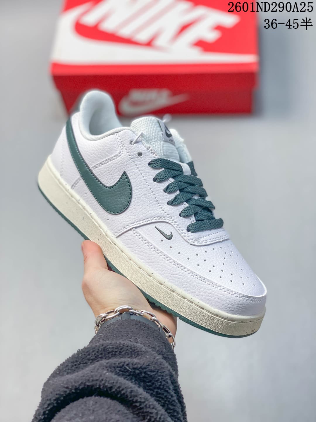 White Nike Court Vision Low sneaker with dark green details, dark laces and an off-white midsole.