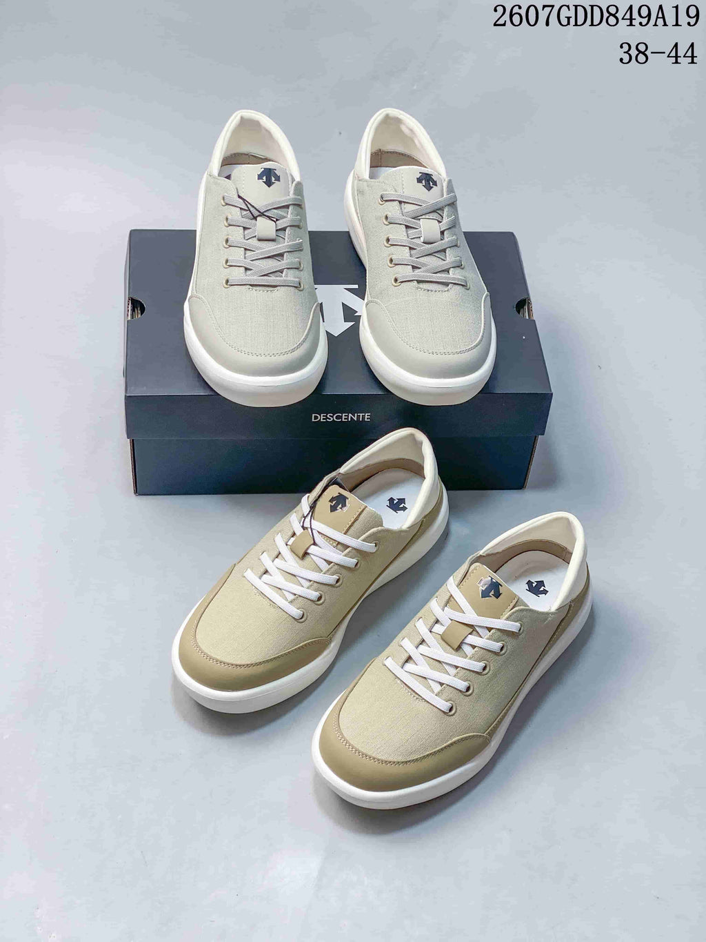 White and beige Descente sneakers arranged together, showing the front profiles, lace systems, logos, shoebox, and style code 2607GDD849A19.
