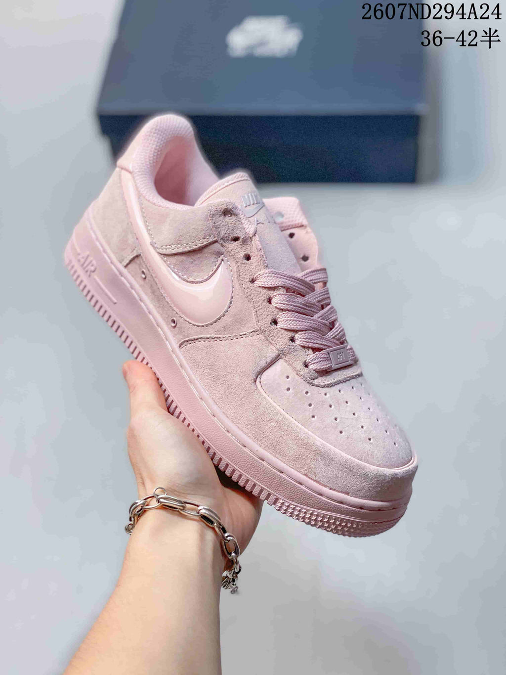 Angled side view of the soft pink Nike low-top sneaker showing the Swoosh, laces, and padded collar.