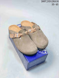 Pair of taupe Birkenstock Boston-style closed-toe mules displayed on a blue branded shoe box; image text shows style reference 2607 TXD126A16 and size range 35–45.
