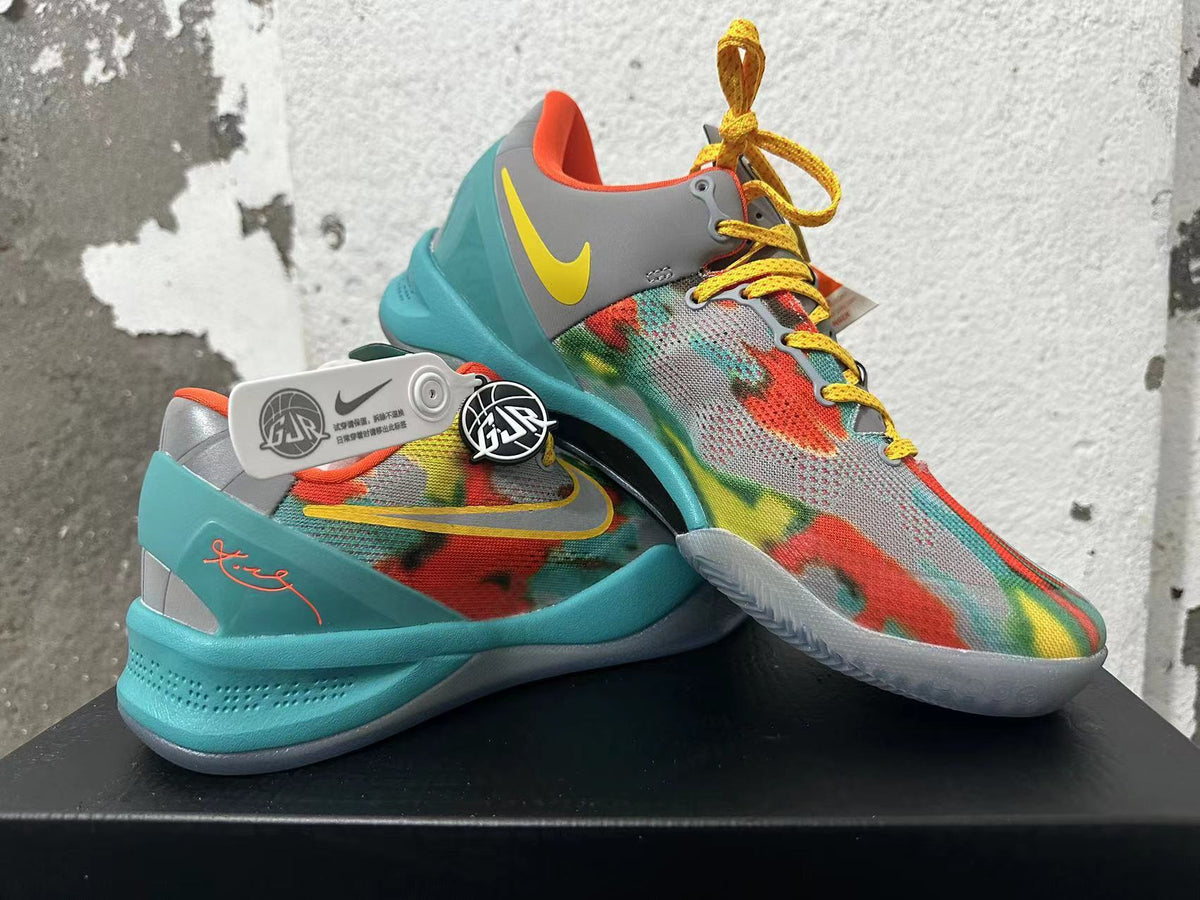 Pair of multicolor Nike basketball shoes with patterned uppers and turquoise soles