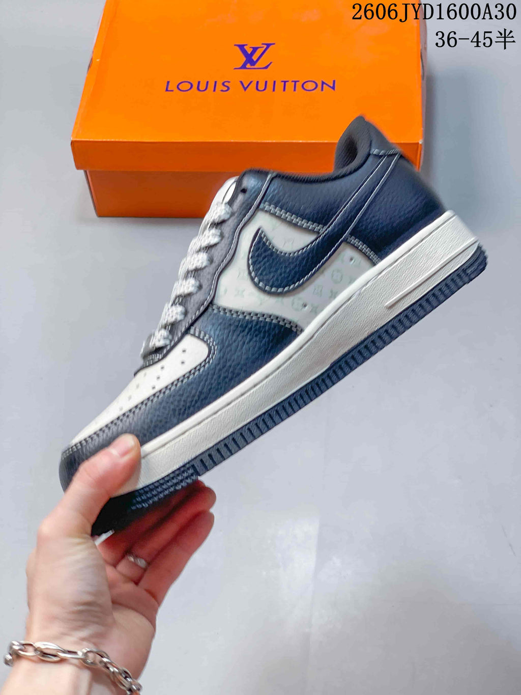 Side view of a navy and white low-top sneaker with patterned panels and contrast stitching