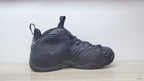 Side profile of a black high-top sneaker with raised circular panel details.