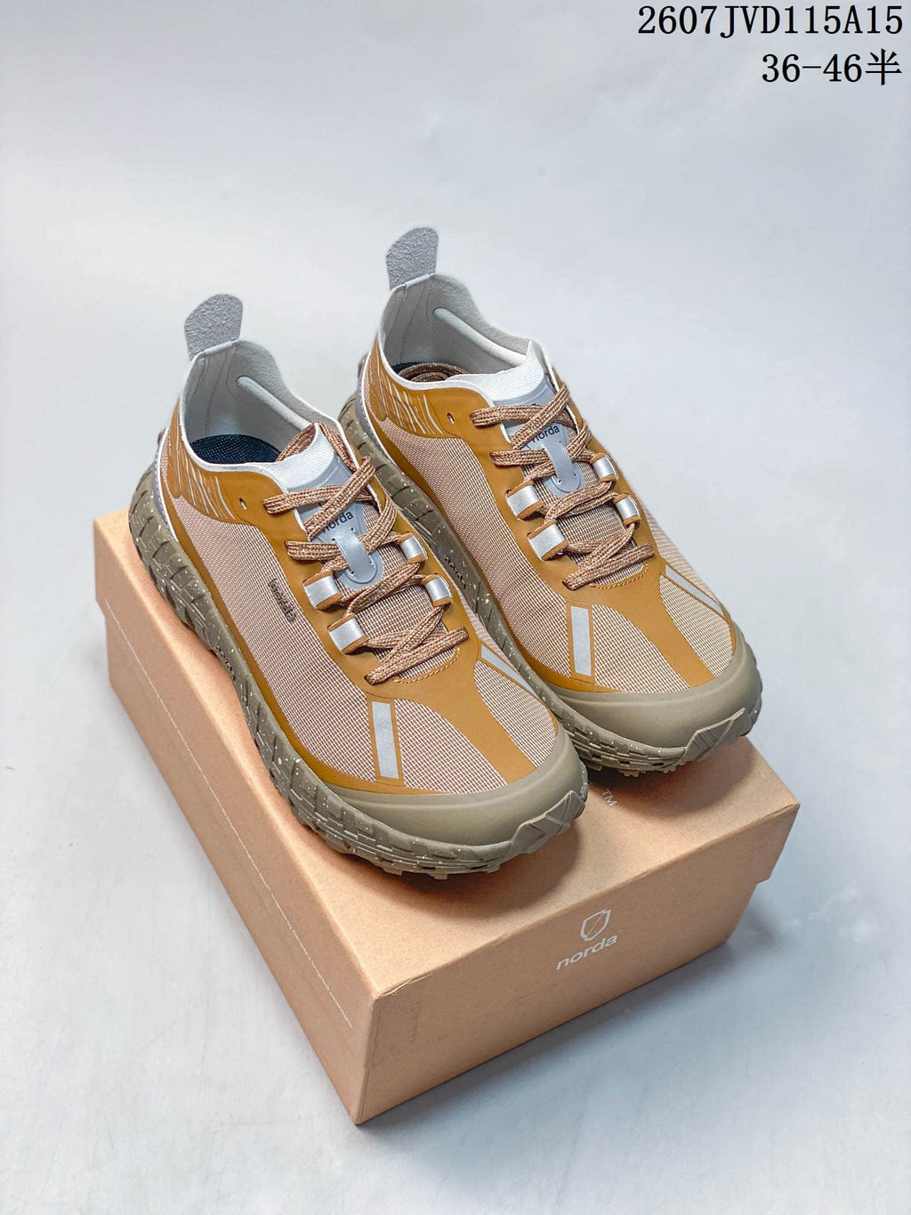 Pair of NORDA 001 G+ sneakers in mustard, beige, gray, and white displayed on a branded shoebox; style code and size range are overlaid.