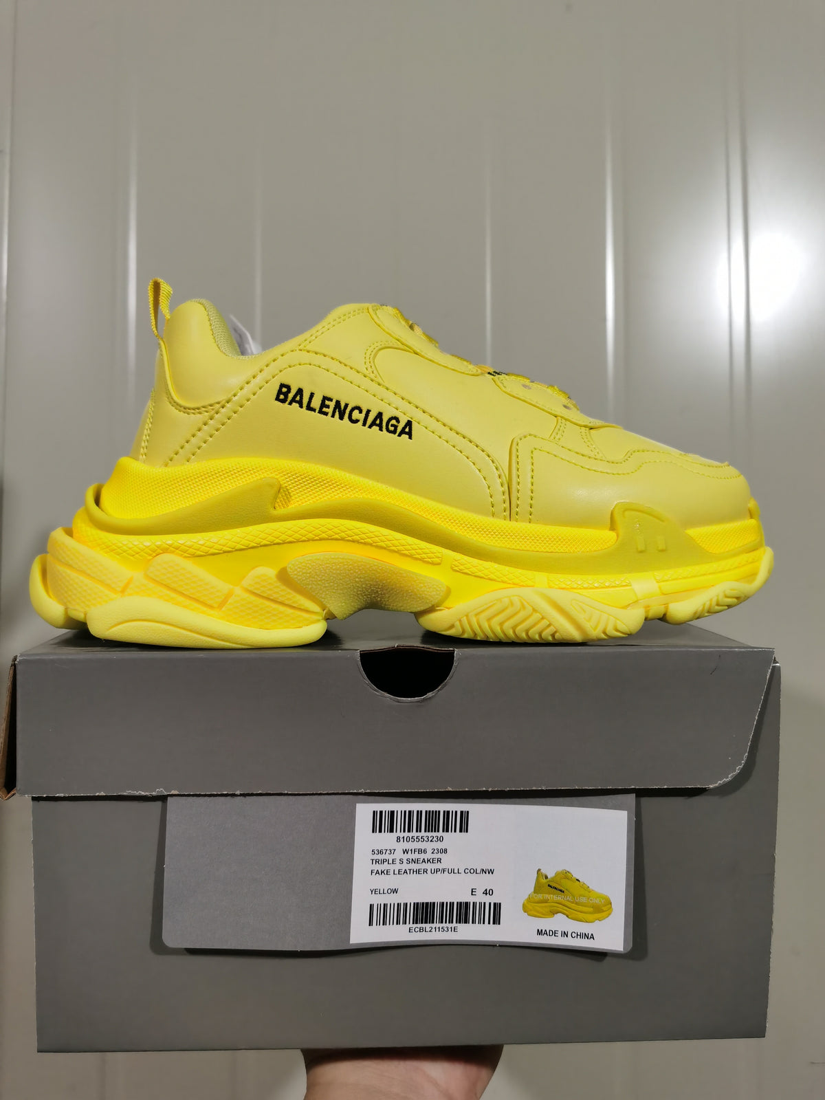 Yellow Balenciaga Triple S sneaker resting on its box, with the box label showing style 2308, yellow color and size E 40.