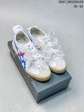 Pair of white Onitsuka Tiger sneakers with blue and red stripes, ribbon-style laces, and a shoebox.