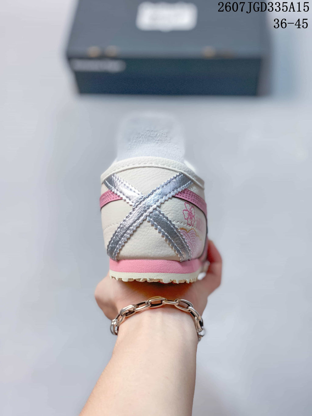 Rear view showing the pink and silver crossed heel accents and pink outsole detail.