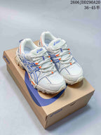 Pair of white ASICS sneakers with blue detailing and orange accents displayed on an ASICS shoebox.