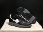 Angled view of one black sneaker with its textured black-and-gray outsole visible behind it.