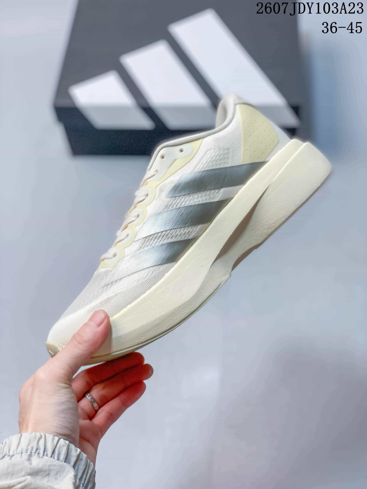 Side profile of the off-white sneaker showing the silver side stripes, mesh-like upper panels and raised sole.