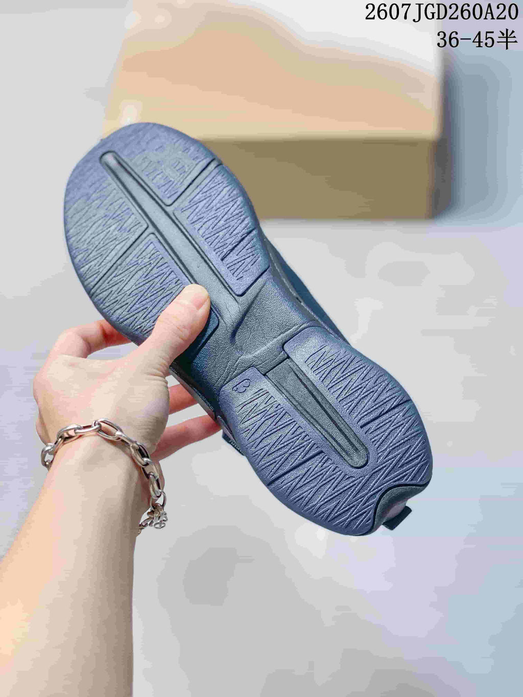 Underside view of a dark navy sneaker showing the segmented outsole and textured tread pattern.