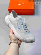 Angled side view of the light gray Nike Free sneaker showing the knit upper, blue Swoosh, padded collar, and white outsole.