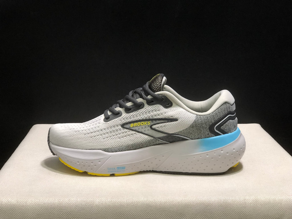 Side profile of one Brooks Glycerin 21 shoe, showing the white upper, grey heel panel, blue midsole accent, yellow outsole edge, and Brooks branding.