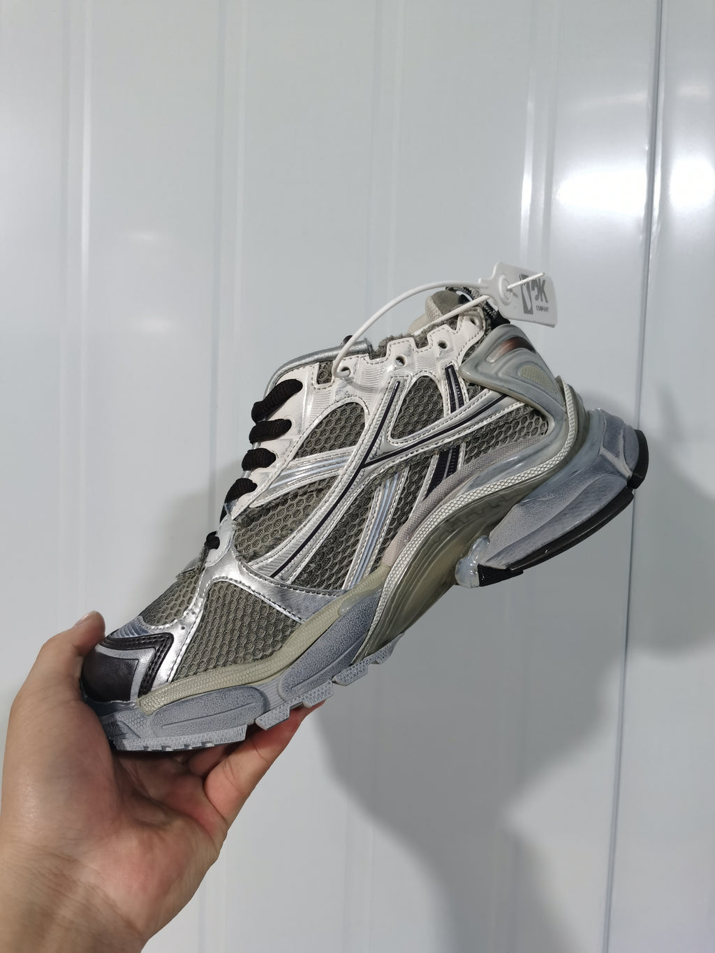 Angled view of the taupe mix New Balance 2000 sneaker showing the mesh-style panels, metallic accents, heel structure, and black outsole.