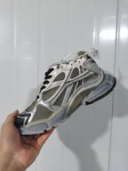 Angled view of the taupe mix New Balance 2000 sneaker showing the mesh-style panels, metallic accents, heel structure, and black outsole.