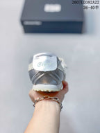 Rear view of the silver sneaker showing the heel construction, light outsole, and branded heel detail.