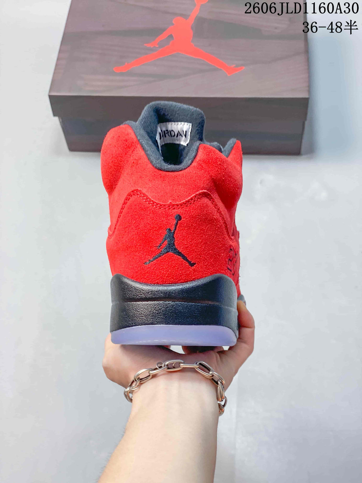 Rear view of the red sneaker with a dark heel logo and midsole.
