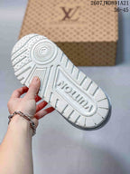Underside of a white sneaker showing the textured outsole and molded branding details.