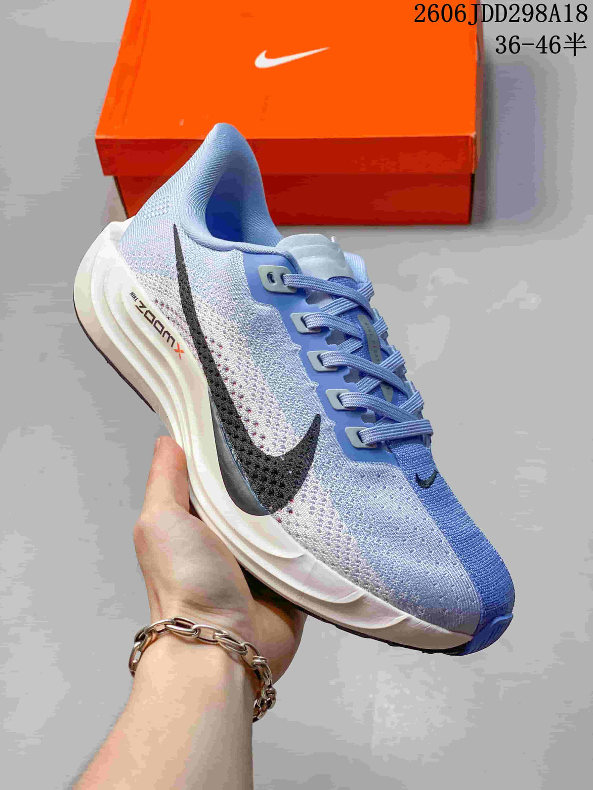 Angled side view of the light blue and white Nike running shoe showing the black Swoosh, blue forefoot panel and white midsole.